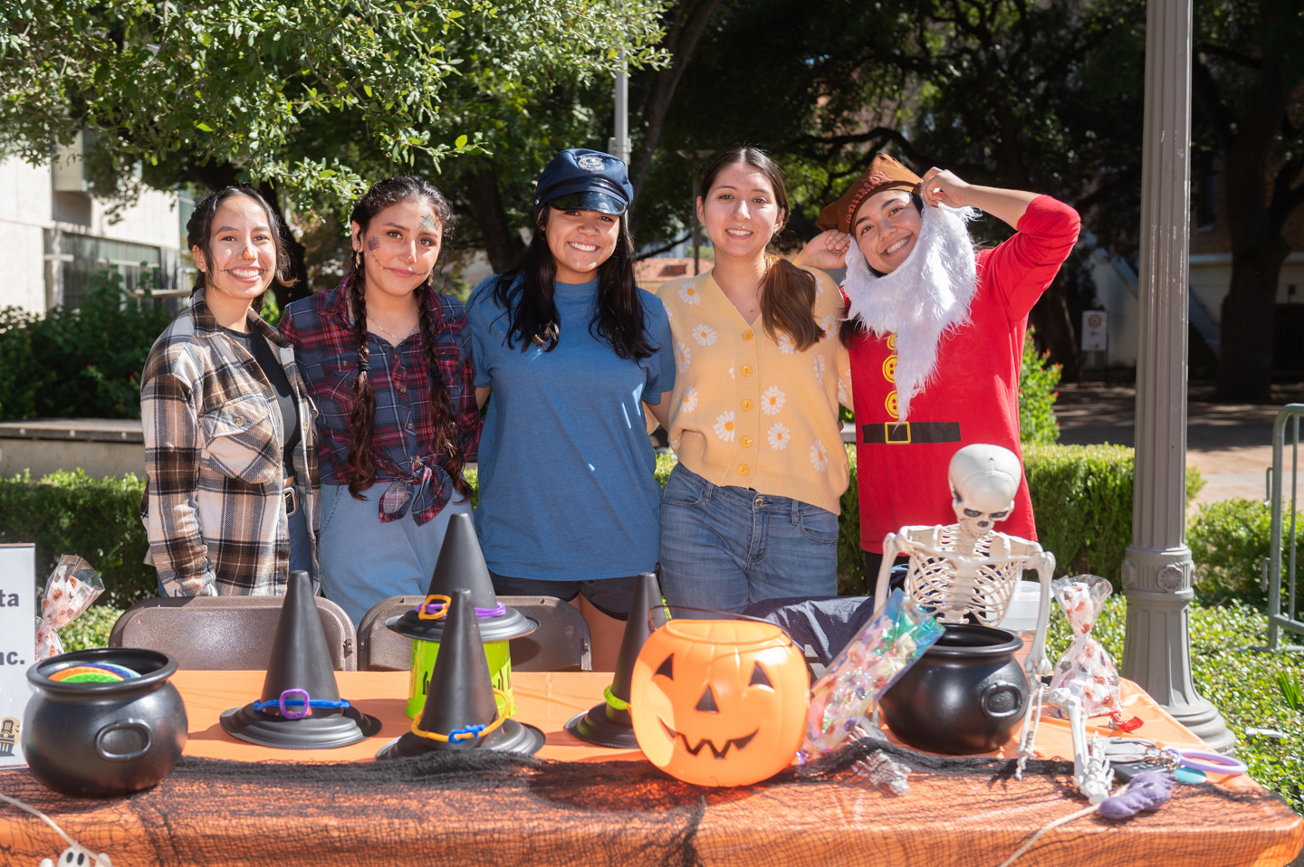 students standing behind a table decorated for Halloween